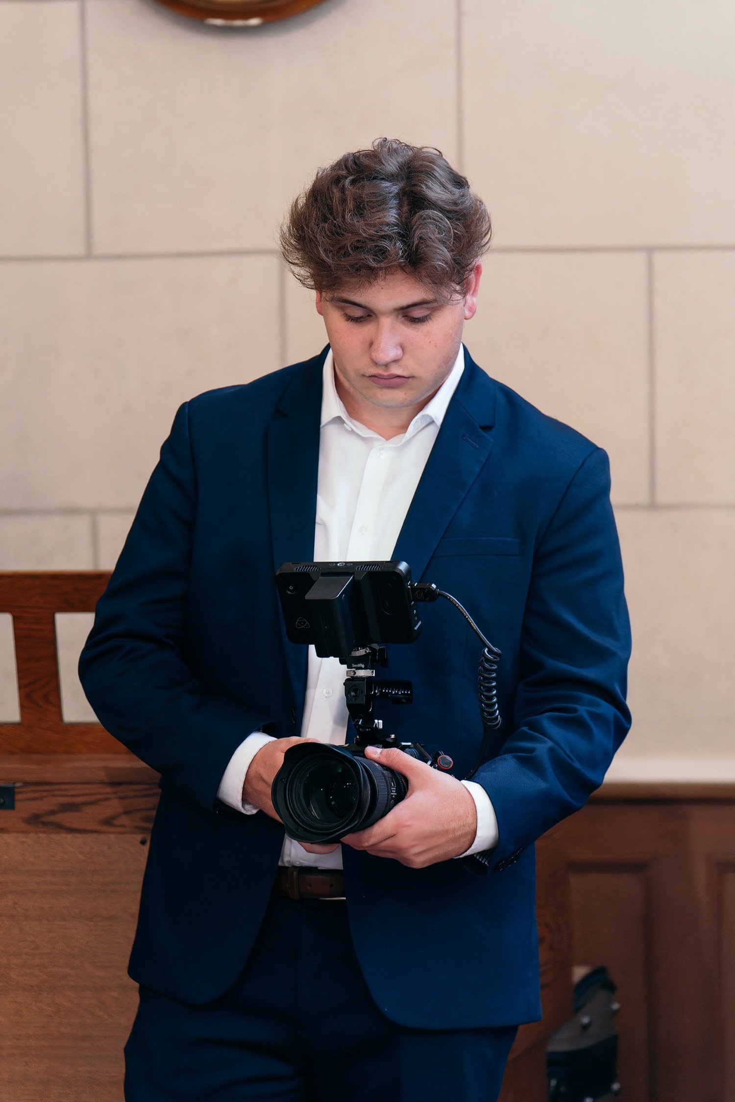 Thomas Darnault, photographe, en costume, appareil photo en main